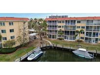 Aerial view of waterfront condo building with boat slips and lush landscaping at 1215 S Portofino Dr # 108, Sarasota, FL 34242