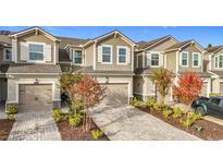 Three-unit townhome complex with attached garages and landscaped yards at 12455 Trailhead Dr, Bradenton, FL 34211