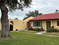 Exterior view of a condo with a red tile roof and lush landscaping at 1318 56Th W St # 1318, Bradenton, FL 34209