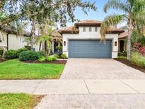 Single-story home with gray garage door, landscaping, and a paved driveway at 19066 Mangieri St, Venice, FL 34293