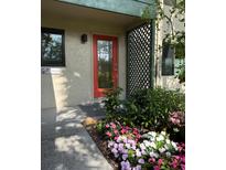 Inviting entryway with a vibrant red door and lush landscaping at 1519 Pelican Point Dr # 191, Sarasota, FL 34231