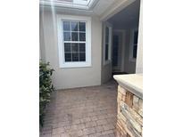 Inviting front porch with brick pavers and stone accents at 1910 Scarlett Ave, North Port, FL 34289