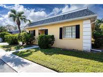 Front view of charming yellow house with manicured lawn at 2413 Aspinwall St # 2413, Sarasota, FL 34237