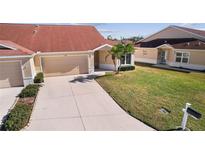 Attractive exterior of a house with a two-car garage and well-maintained lawn at 2608 Edgewater Ct, Palmetto, FL 34221