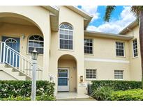 Tan two-story condo building with blue door and lush landscaping at 4250 Players Pl # 2615, Sarasota, FL 34238