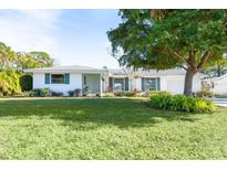 Ranch-style home with a large front yard and mature tree at 4515 Falcon Ridge Dr, Sarasota, FL 34233