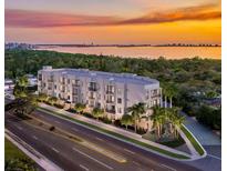 Aerial view of a modern building complex near the water at sunset at 4950 Remington Dr # 208, Sarasota, FL 34234