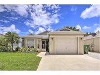 House exterior featuring a beige one-story home with a two-car garage and a well-maintained lawn at 6115 39Th W Ave, Bradenton, FL 34209