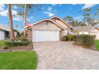 Brick home with a paved driveway and two-car garage at 7755 Pine Trace Dr # 7755, Sarasota, FL 34243