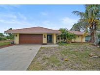 Charming single-story home with a brown garage door and a neatly landscaped lawn at 1212 Windward Dr, Osprey, FL 34229