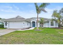 Single-story home with attached garage, landscaping, and palm tree at 2008 Tocobaga Ln, Nokomis, FL 34275