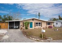 Cute ranch home with teal door, screened porch, and well-maintained lawn at 2206 25Th W Ave, Bradenton, FL 34205