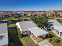 Single-story home with carport, lush landscaping, and canal views at 4714 Potomac Cir, Bradenton, FL 34210