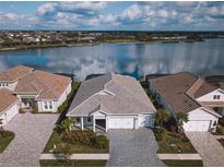 Aerial view of a waterfront home community with houses, landscaping, and a lake at 8043 Waterbend Trl, Sarasota, FL 34240