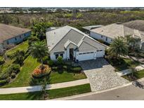 Beautiful single-story home featuring a three-car garage, lush landscaping and a tile roof at 8261 Grande Shores Dr, Sarasota, FL 34240