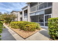 Landscaped walkway leading to condo building with screened patio at 8901 Veranda Way # 116, Sarasota, FL 34238