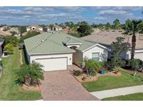 Attractive single-Gathering home with green roof, brick driveway, and landscaped yard at 11698 Anhinga Ave, Venice, FL 34292