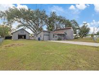 Gray house with detached garage and large backyard at 4904 9Th Street E Ct, Bradenton, FL 34203