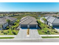 Aerial view of three attached homes with two-car garages and paved driveways at 5514 Tidal Breeze Cv, Bradenton, FL 34211