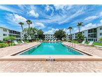Refreshing community pool with lounge chairs at 5938 Welcome Rd # H22, Bradenton, FL 34207