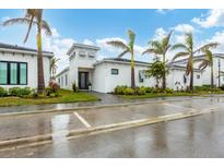 White modern home with palm trees and a landscaped yard at 6404 Pigeon Plum Way, Bradenton, FL 34210