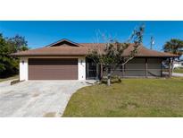 Single-story home with brown roof and screened porch at 7450 Ebro Rd, Englewood, FL 34224
