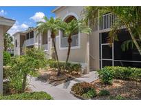 Exterior view of condo building with lush landscaping and walkway at 9490 High Gate Dr # 2013, Sarasota, FL 34238