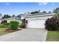 House exterior featuring a white garage door and well-manicured landscaping at 11813 Holly Hock Dr, Lakewood Ranch, FL 34202
