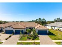 Aerial view of a two-story home with tile roofs and two-car garages at 14369 Eagle Branch Dr, Nokomis, FL 34275