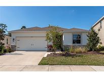 Charming single-story home with a well-manicured lawn and a two car garage on a sunny day at 2164 Midnight Pearl Dr, Sarasota, FL 34240