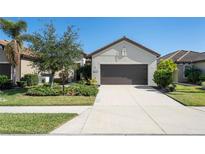 Single-story home with a two-car garage and landscaped front yard at 491 Casalino Dr, Nokomis, FL 34275