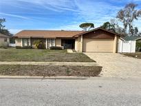 Single-story home with attached garage and landscaped lawn at 7811 Snapping Turtle Ct, Hudson, FL 34667