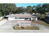 Aerial view of a single-Gathering home with a large front yard and driveway at 975 S Tuttle Ave, Sarasota, FL 34237