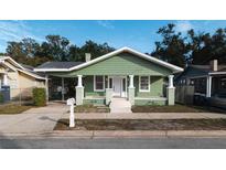 Charming green house with a porch and well-maintained lawn at 1010 E Lake Ave, Tampa, FL 33605