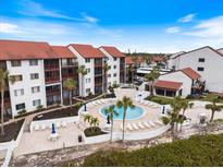 Aerial view of condo complex with pool and surrounding landscape at 1604 Stickney Point Rd # 102, Sarasota, FL 34231