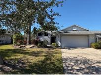 Single story home with white exterior, gray roof, and landscaped yard at 1666 Pintail Way # 9, Sarasota, FL 34231