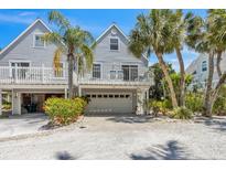 Two-story beach home with private balconies and attached garage at 235 64Th St, Holmes Beach, FL 34217