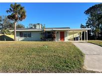 Light green single story home with carport and well-manicured lawn at 2710 Hibiscus St, Sarasota, FL 34239