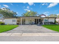 Property exterior with carport and nicely landscaped lawn at 3530 Tree Line Dr # 4, Sarasota, FL 34231