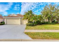 Attractive single-story home with a three-car garage and lush landscaping at 4677 Sweetmeadow Cir, Sarasota, FL 34238