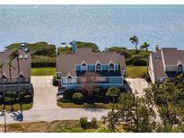 Beautiful waterfront home featuring a brick driveway, mature landscaping and stunning water views at 73 Tidy Island Blvd, Bradenton, FL 34210