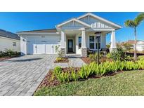 White farmhouse exterior with a covered porch and a gray paver driveway at 8112 Slipway Dr, Sarasota, FL 34240