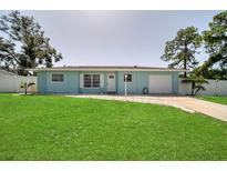 Ranch style home with a light blue exterior, spacious lawn and attached garage at 881 Polaris Rd, Venice, FL 34293