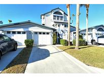 Exterior view of a charming two-story home with attached garage and lush landscaping at 1243 Siesta Bayside Dr # D, Sarasota, FL 34242