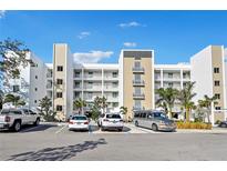 Modern building exterior with ample parking and tropical landscaping at 1703 N Tamiami Trl # 209, Sarasota, FL 34234