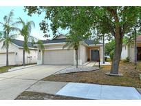 Beige house with gray door, landscaping, and driveway at 1378 Daryl Dr, Sarasota, FL 34232