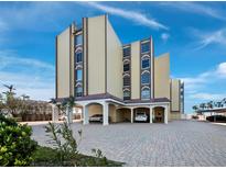 Tan three-story building with covered parking and ocean views at 4215 Gulf Of Mexico Dr # 103, Longboat Key, FL 34228