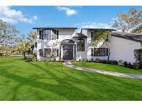 Two-story house with white exterior, dark gray accents, and a manicured lawn at 6706 88Th E St, Bradenton, FL 34202