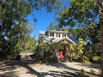 Charming craftsman home with a red front door, surrounded by lush landscaping at 671 41St St, Sarasota, FL 34234