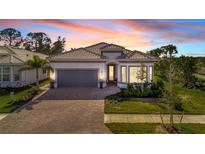 Attractive single-story home with gray garage door and paver driveway at 10201 Beach Dune Dr, Englewood, FL 34223